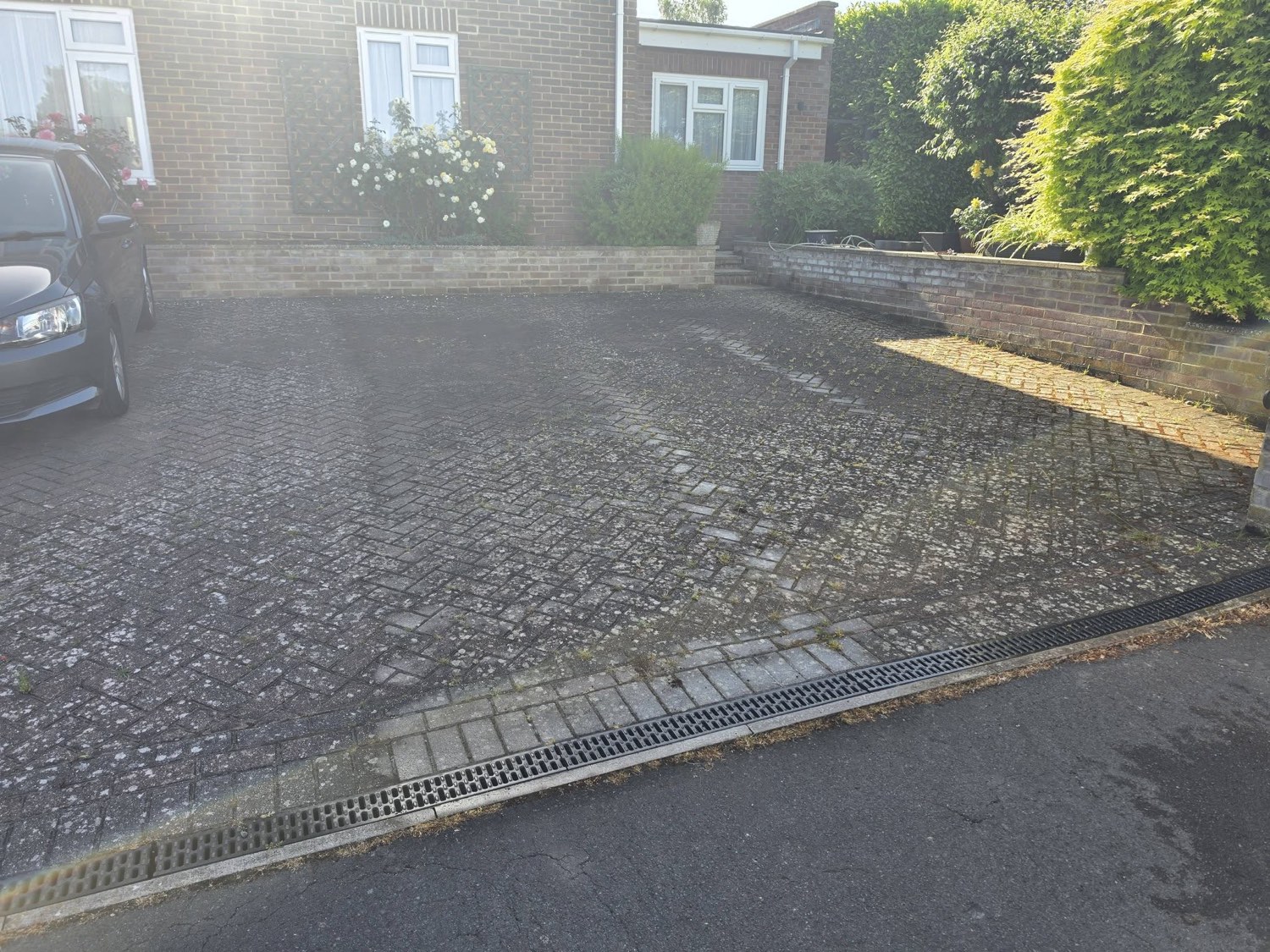 Tired driveway covered in moss and weeds before being replaced by Green Leaf Landscape Services