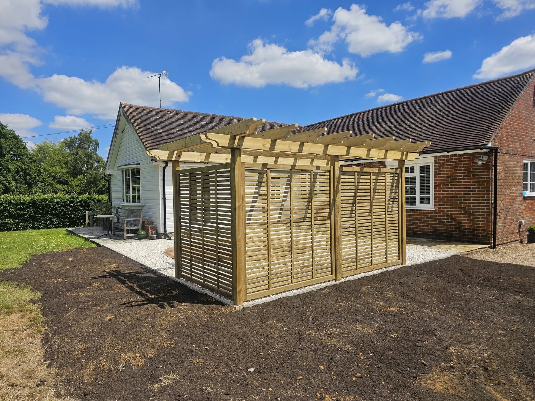 Newly built timber pergola with slatted privacy screens, completed by Green Leaf Landscape Services in Kent