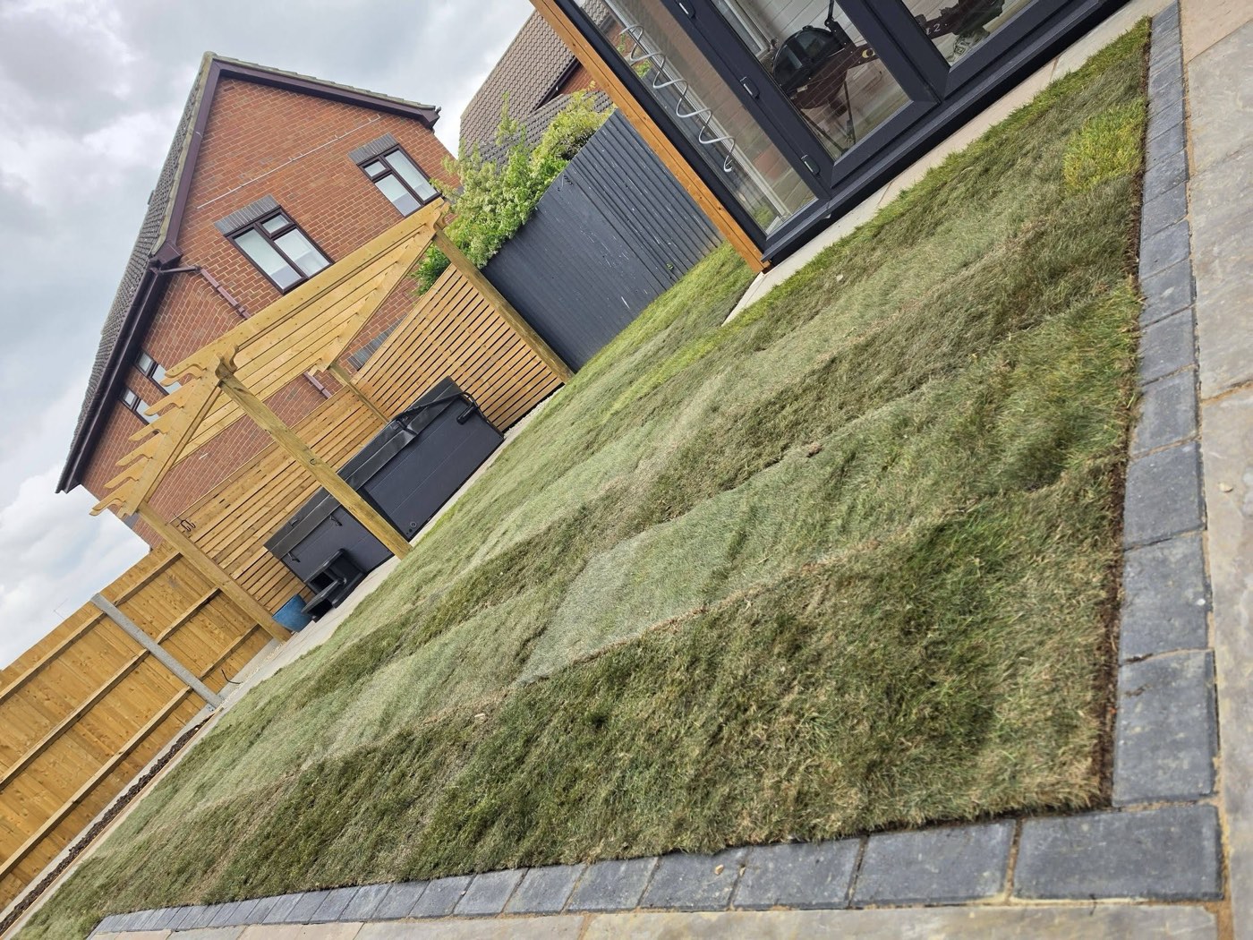 Freshly laid turf running up to a new paved edge, completed by Green Leaf Landscape Services near Tonbridge